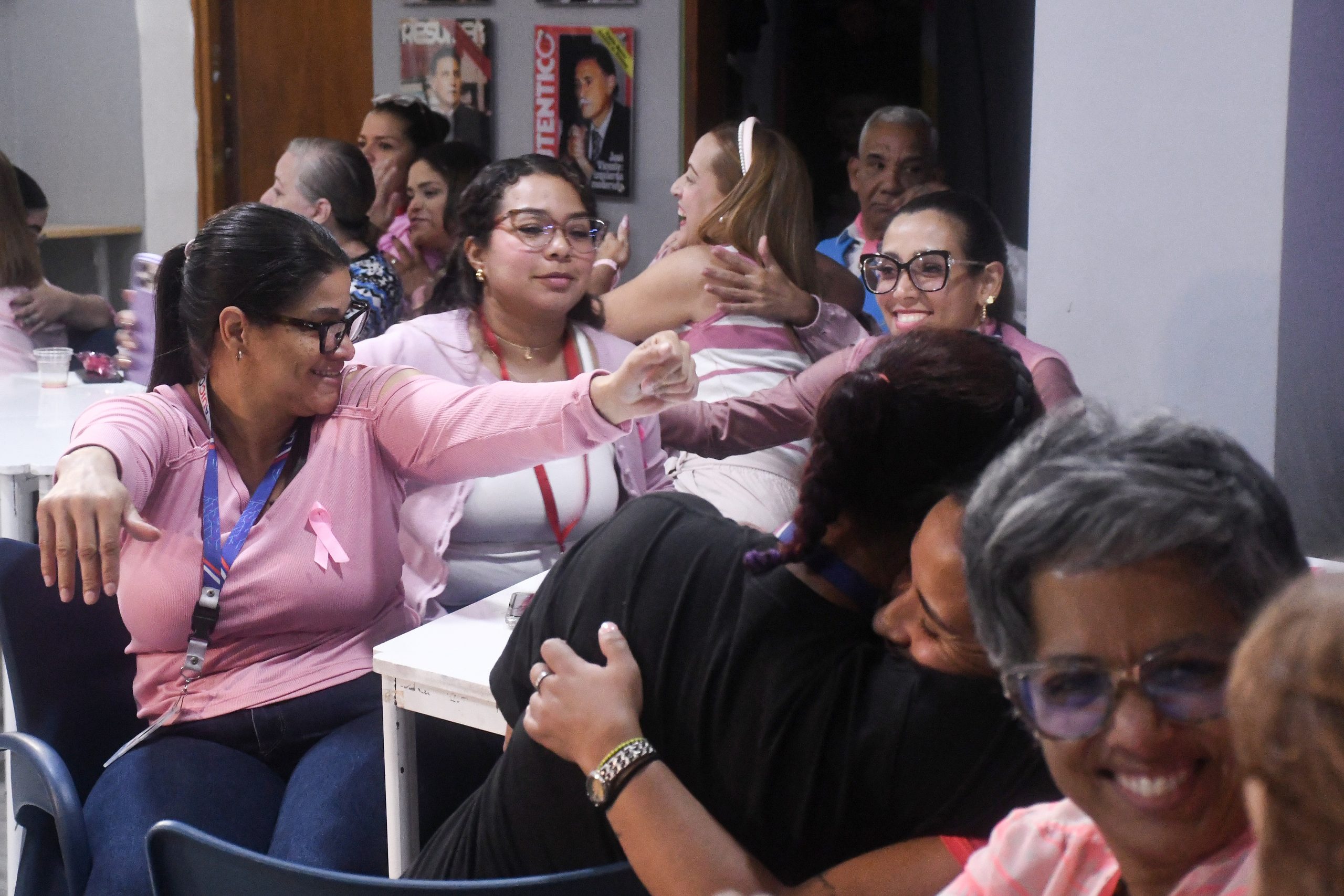 Abrazos grupales entre participantes del evento de café Rosa