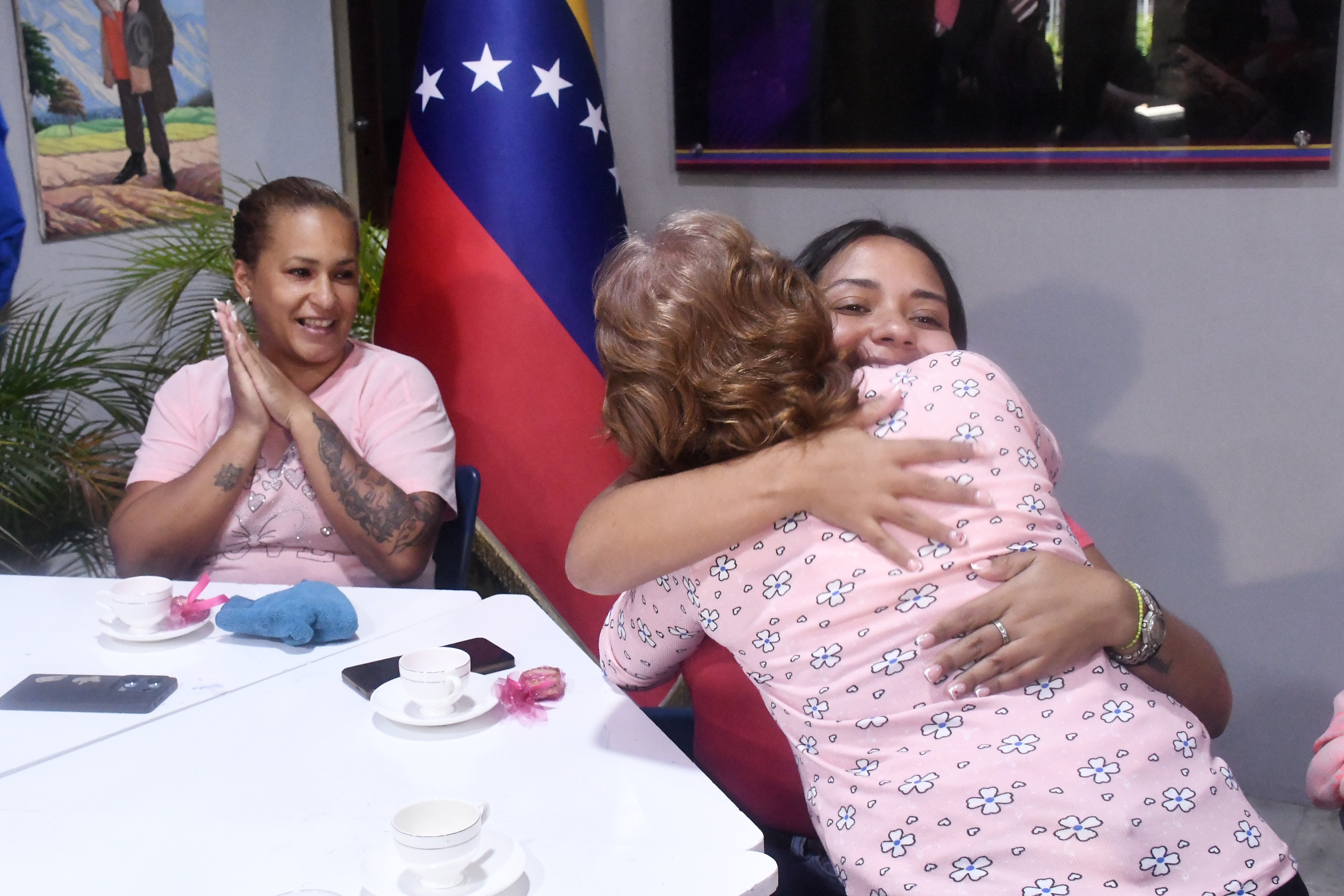 Abrazos grupales entre participantes de conversatorio de Café Rosa